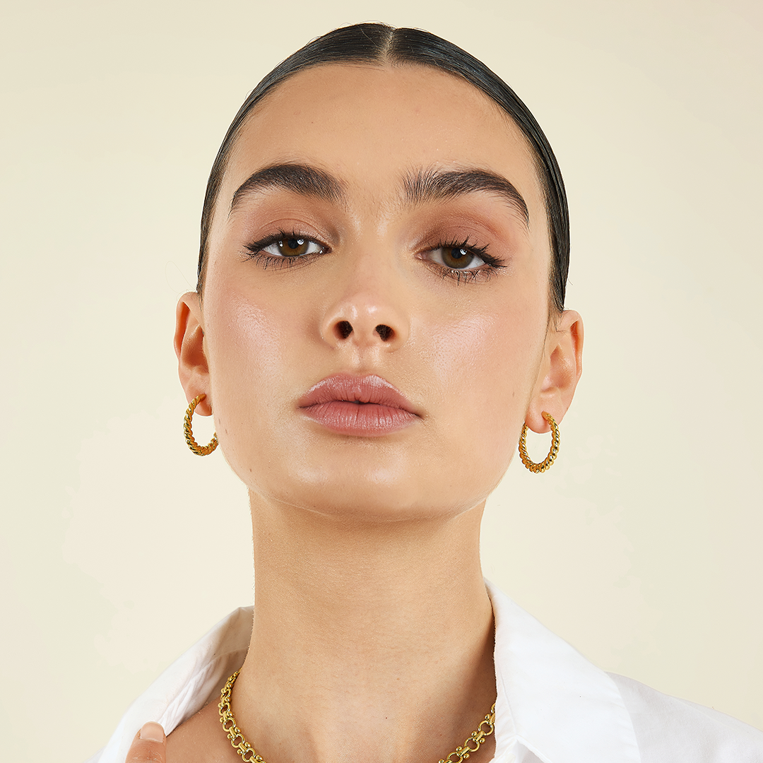 gold hoops inspired by intricate details of the Eiffel tower in ears close up of girls face