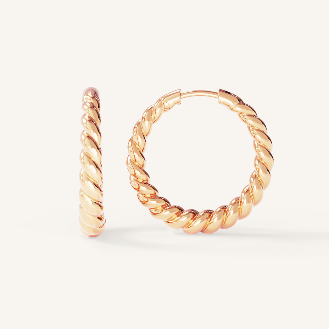 rose gold hoops inspired by intricate details of the Eiffel tower on white background