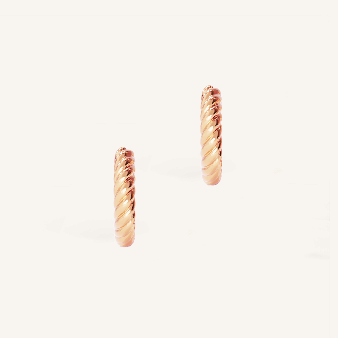 rose gold delicate hoops with a twist design on white background 
