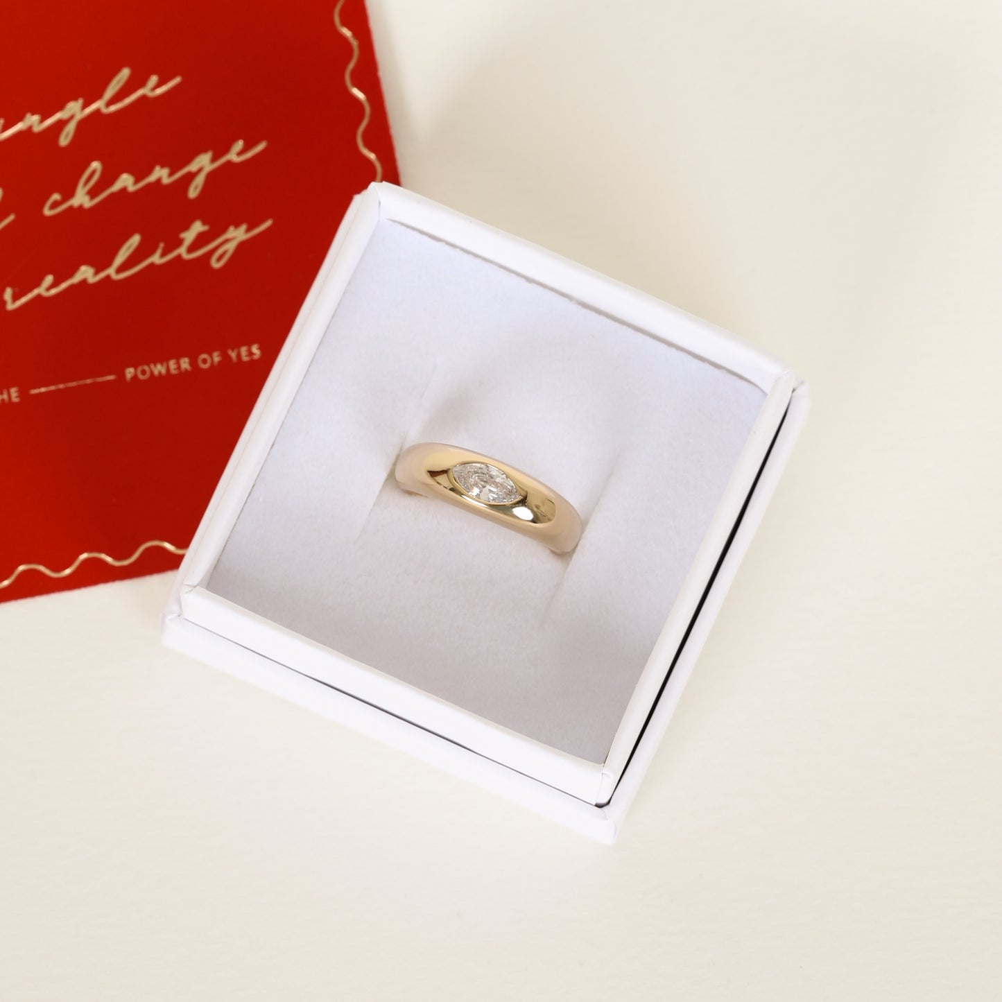 gold ring inspired by the Louvre's architecture with Marquise cut white cubic zirconia bezel set on white ring box