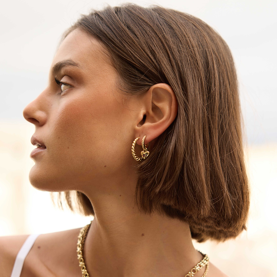 gold hoops inspired by intricate details of the Eiffel tower on the ear on a girl in paris 