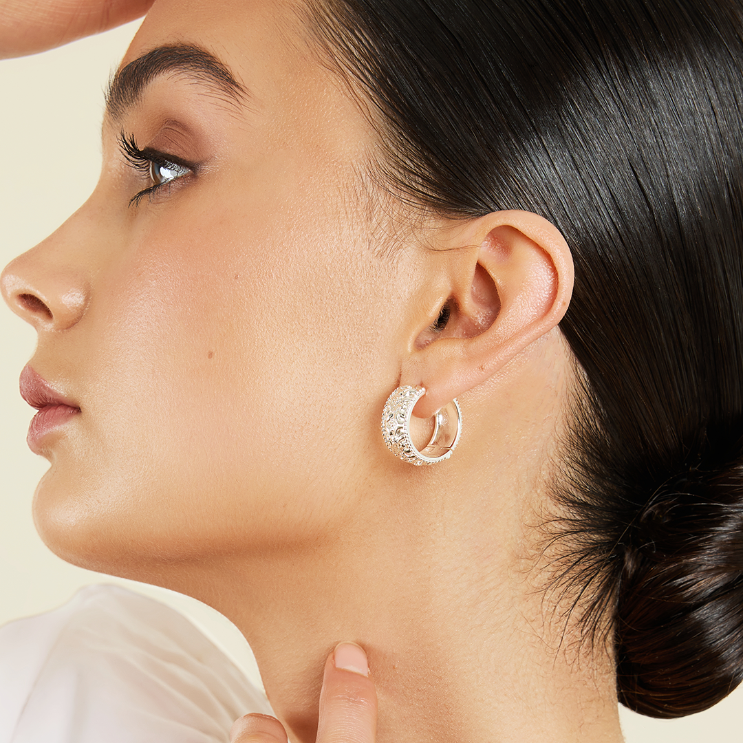 intricately designed statement silver hoops in ear side profile