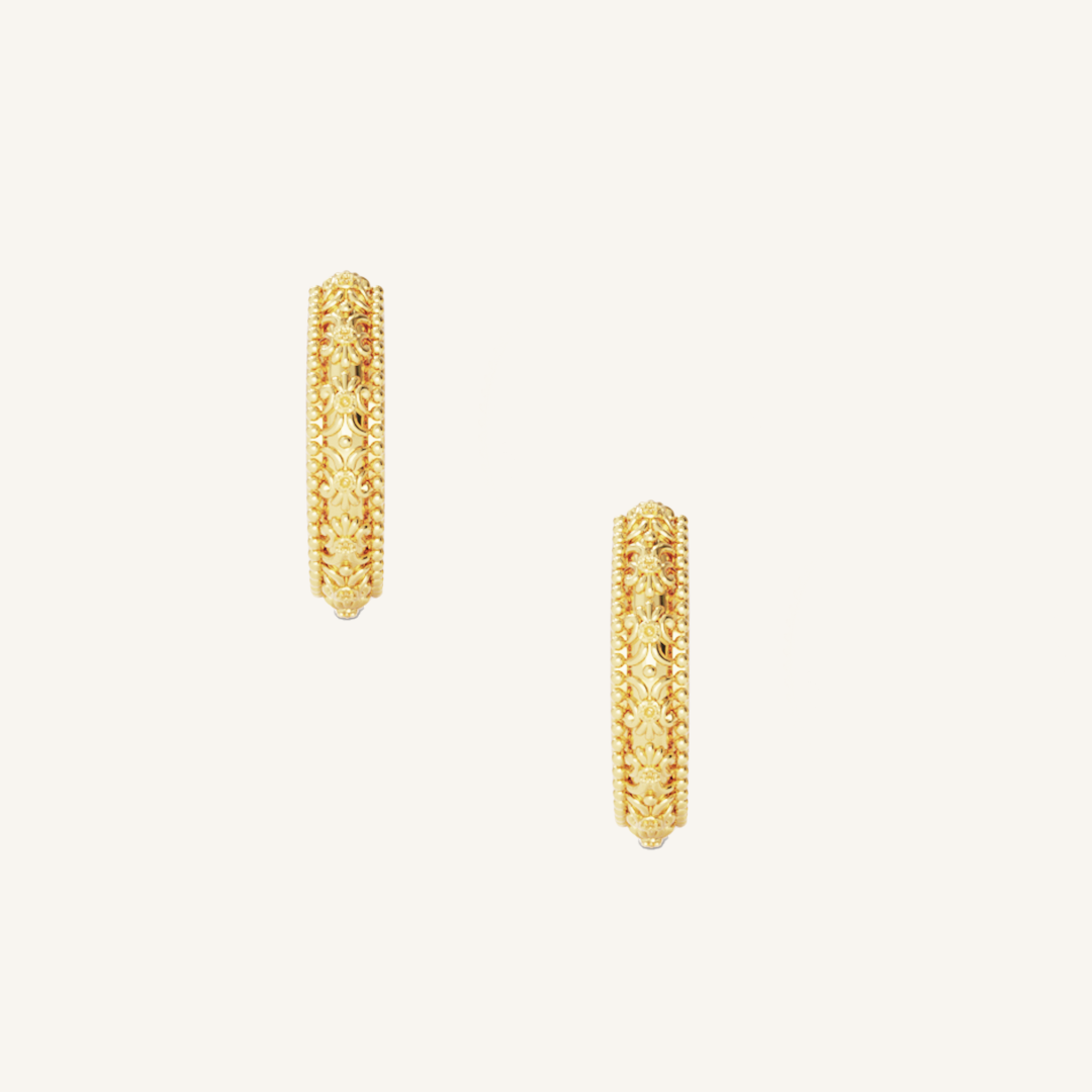 intricately designed gold hoops on white background