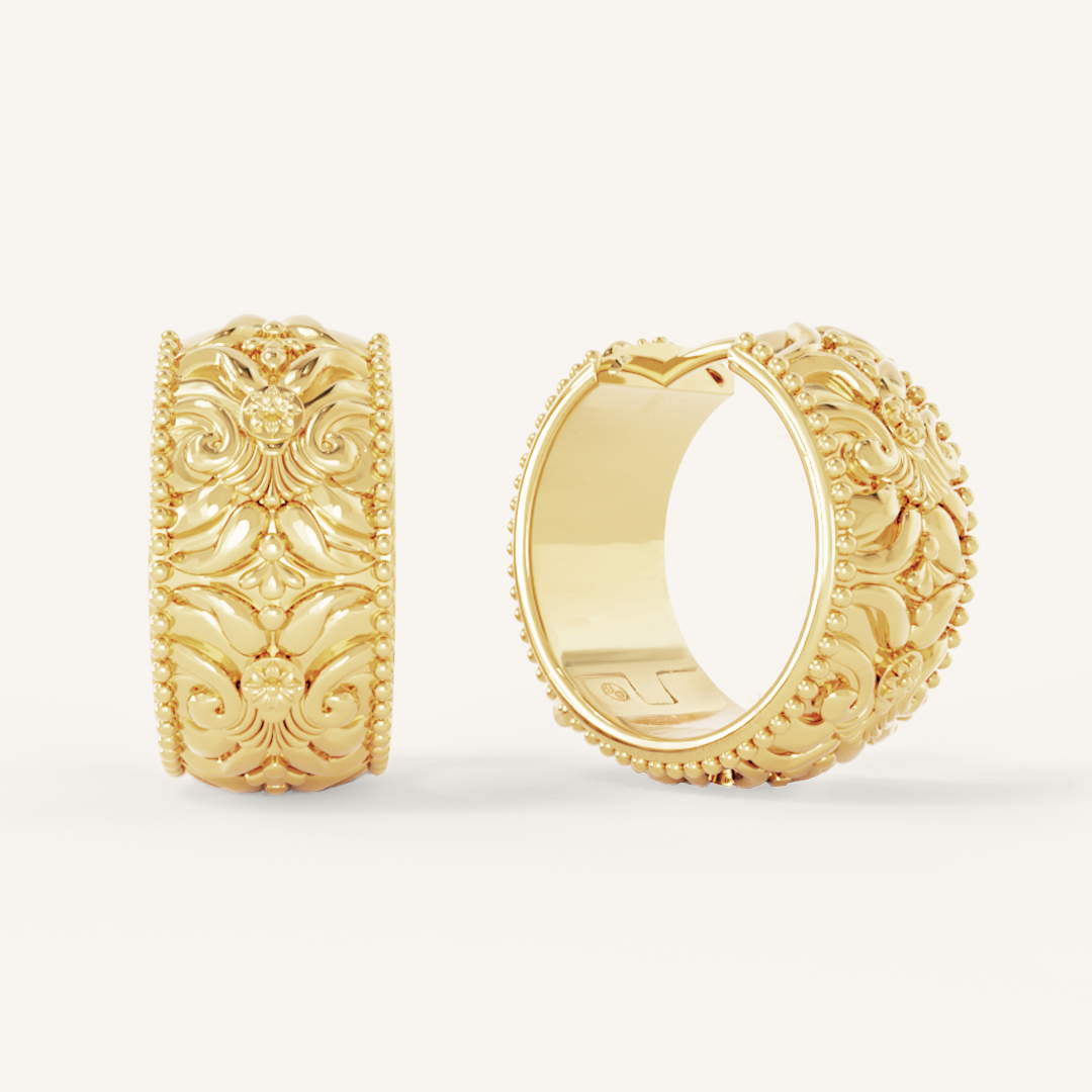 intricately designed statement gold hoops on white background