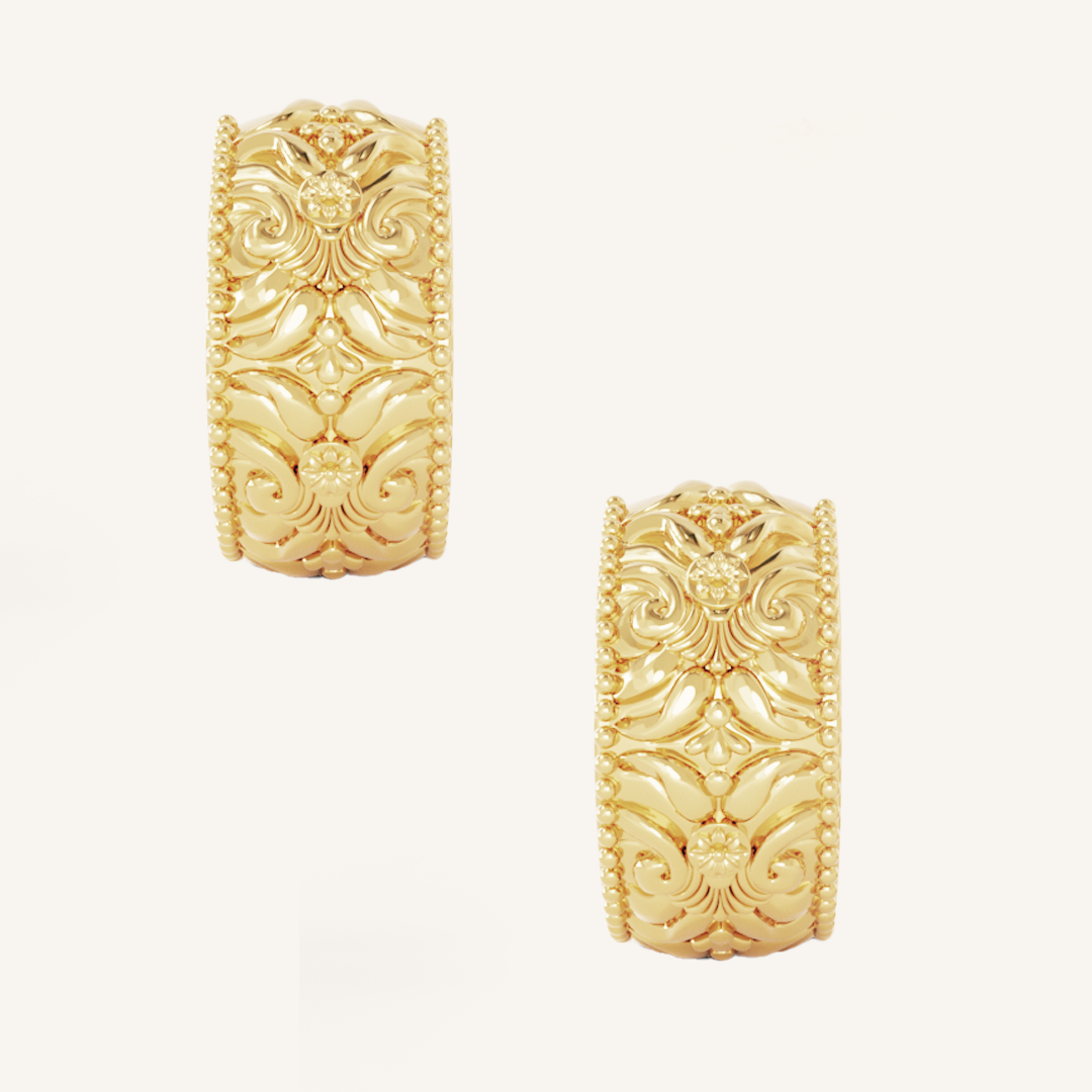 intricately designed statement gold hoops on white background