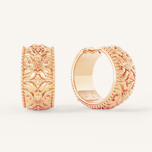 intricately designed statement rose gold hoops on white background