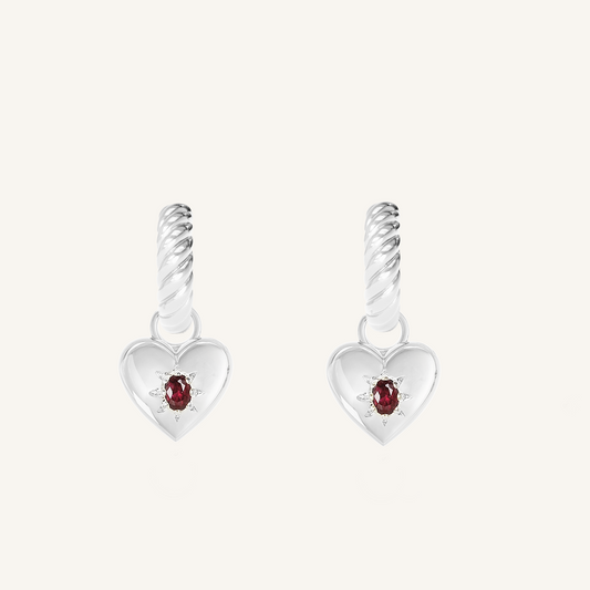 silver hoops with heart charms with deep red oval cubic zirconias on white background