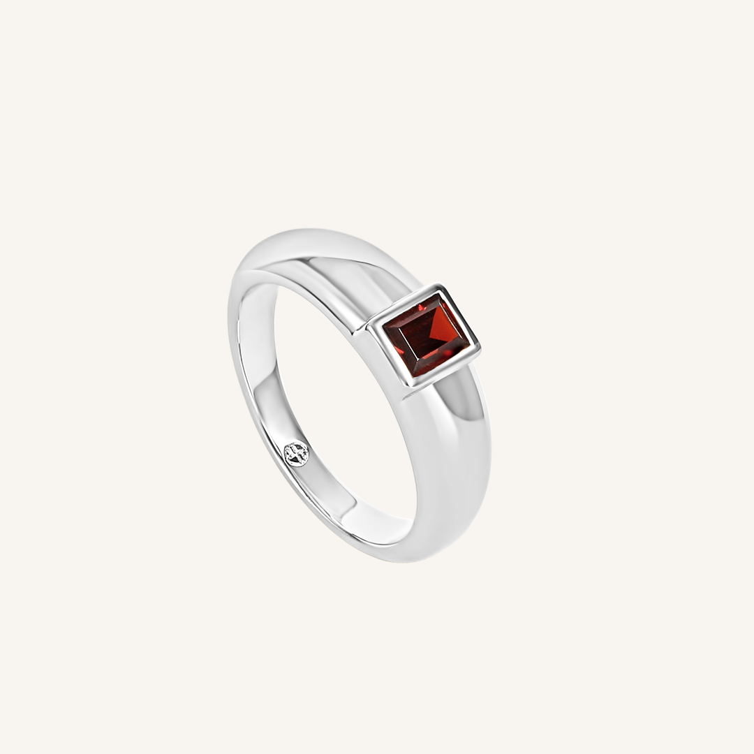 silver ring inspired by the city of love with a deep red square cubic zirconia bezel set on white background