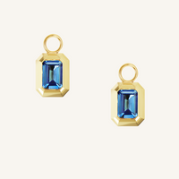 rectangular gold hoop charms with Blue emerald cut cubic zirconias bezel set on white background 