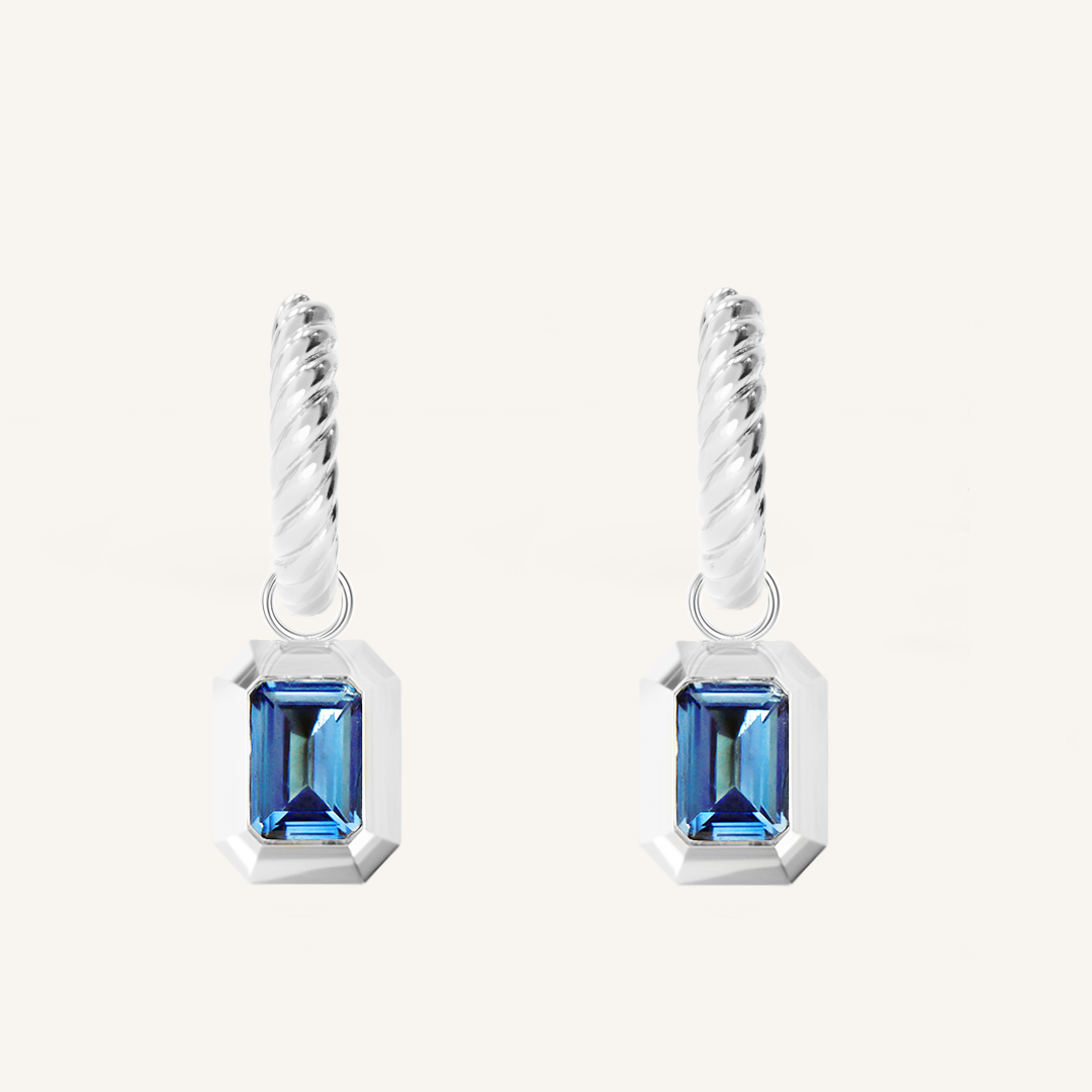 silver hoops with Blue emerald cut cubic zirconias bezel set Inspired by the halls of Versailles on white background 