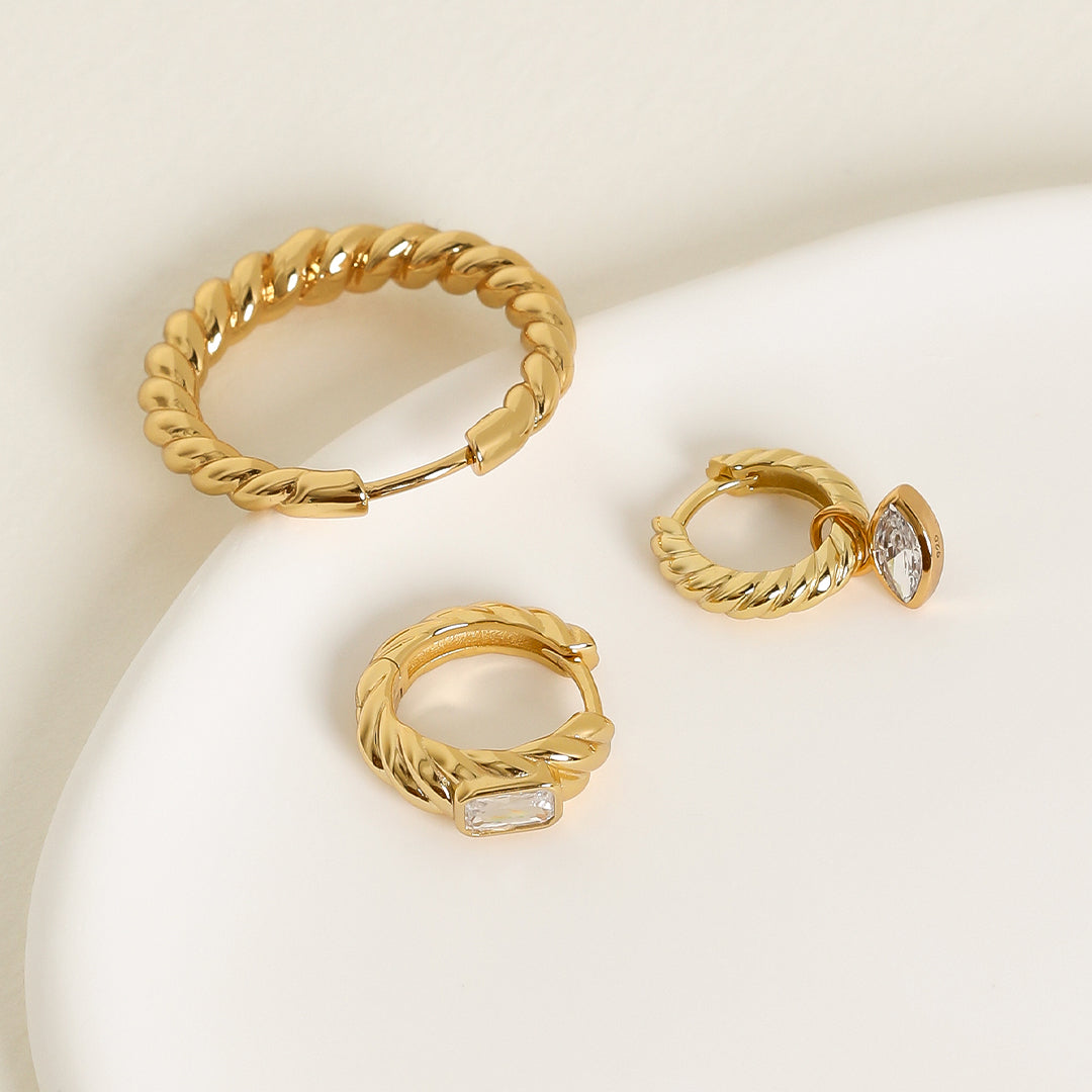 gold hoops inspired by intricate details of the Eiffel tower on white background