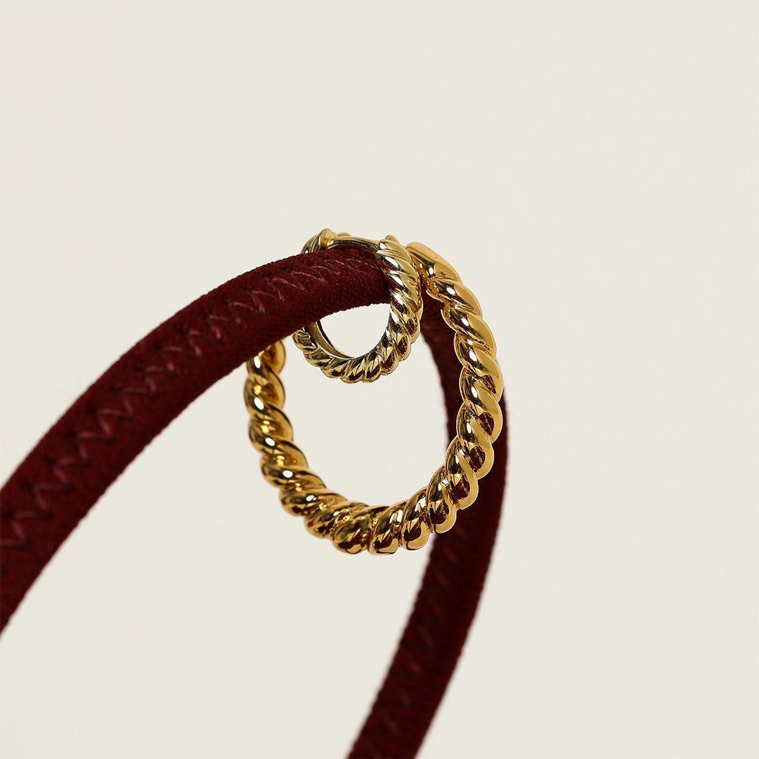 gold hoops inspired by intricate details of the Eiffel tower on white background