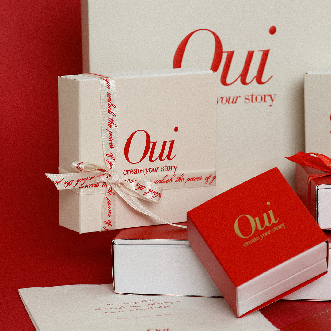 Red, gold and white gift wrapping and ribbon on red background inspired by Paris and the word Oui